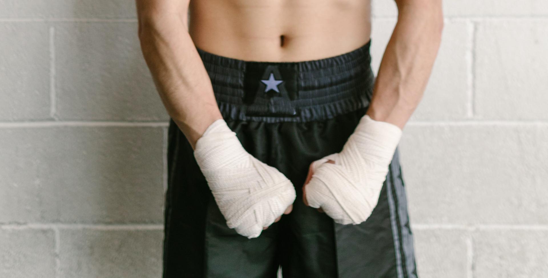 Ein Boxer trägt eine schwarze Trainingshose und ist bereit für den Kampf gegen Hodenkrebs
